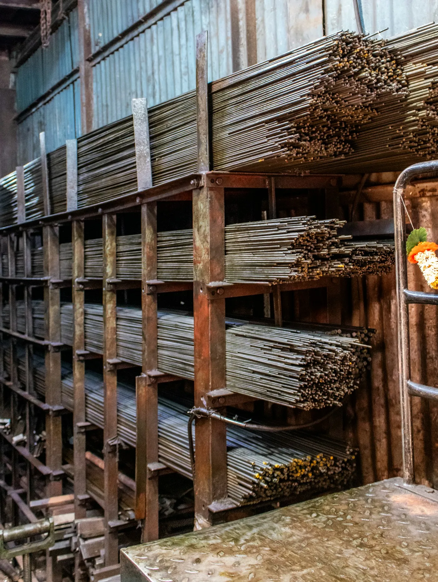 Long metal rods stacked in an industrial warehouse